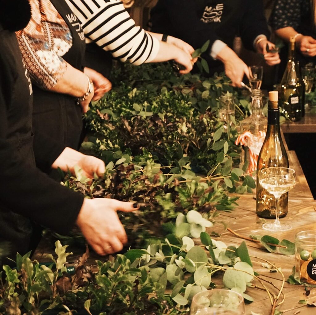 cropped shot of hands making green foliage wreaths